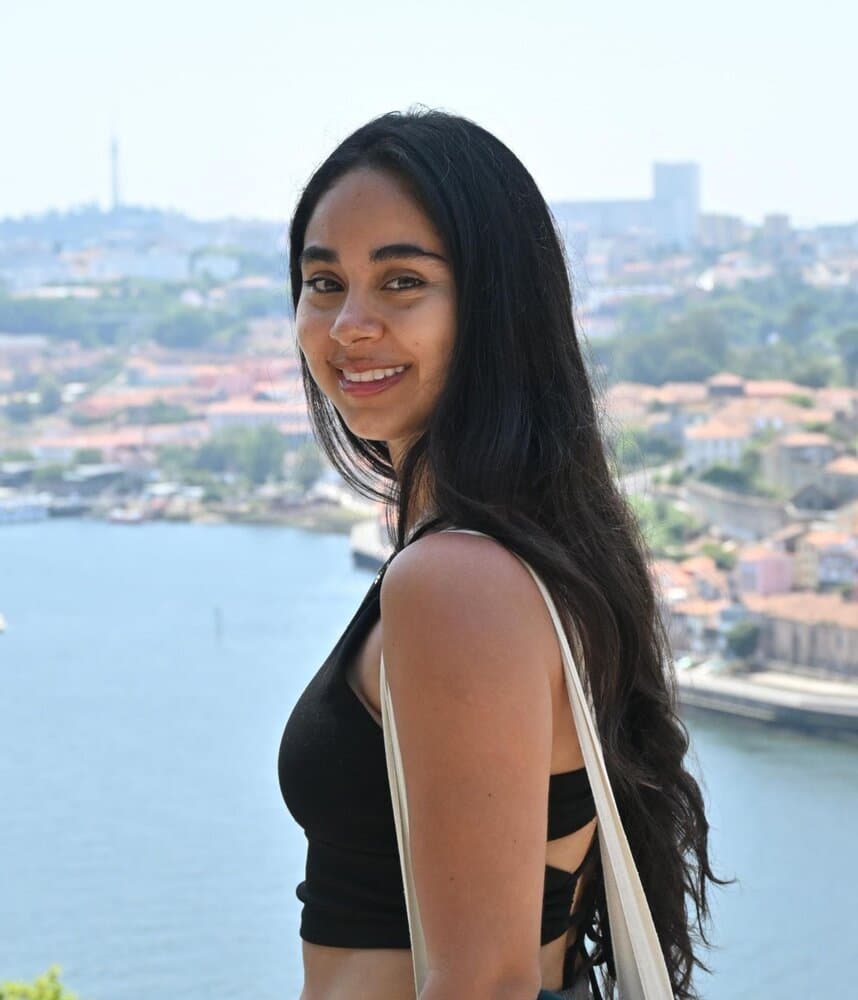 Marisol Baeza, co-founder and architect at Materia Studio, outdoors overlooking a city and river.